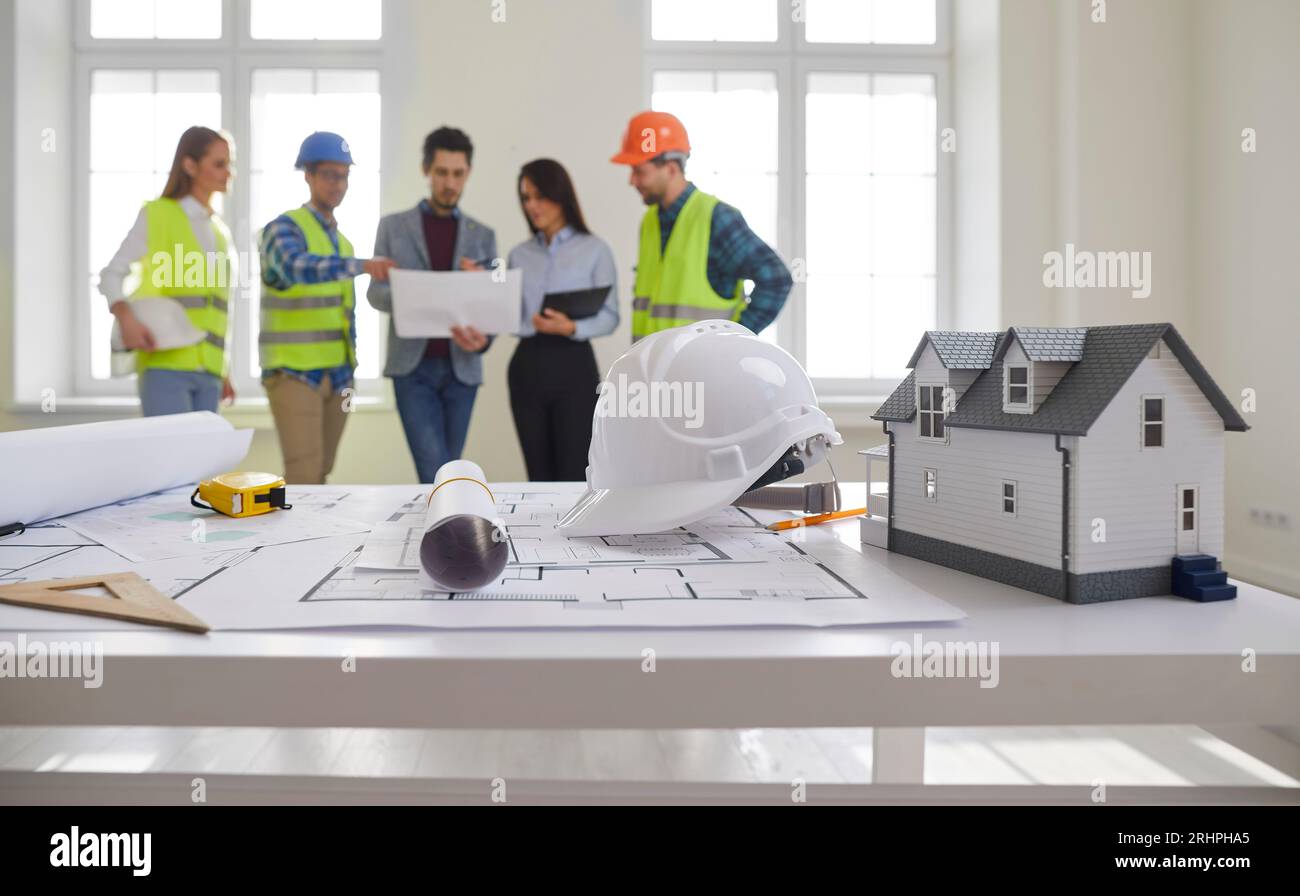 Engineers and architects standing on a building site with architectural plan. Stock Photo