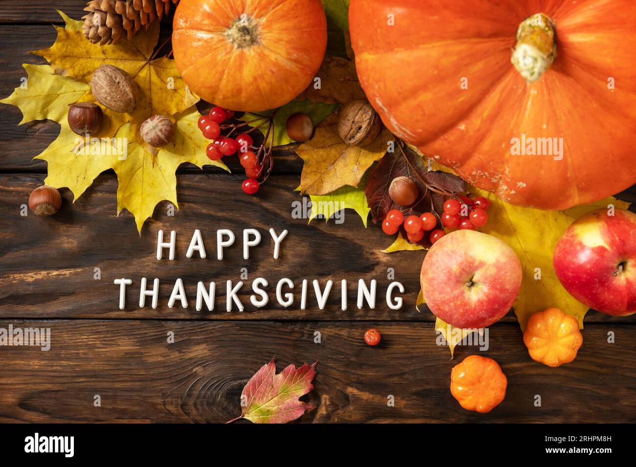 Autumn Day Thanksgiving background. Festive autumn decor from ripe pumpkins, berries and leaves on a wooden background. View from above. Stock Photo