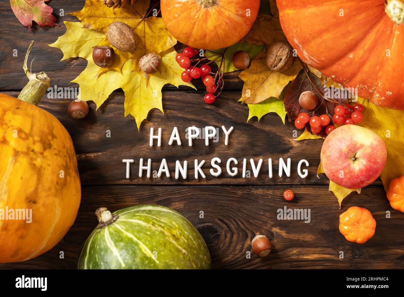 Autumn Day Thanksgiving background. Festive autumn decor from ripe pumpkins, berries and leaves on a wooden background. View from above. Stock Photo