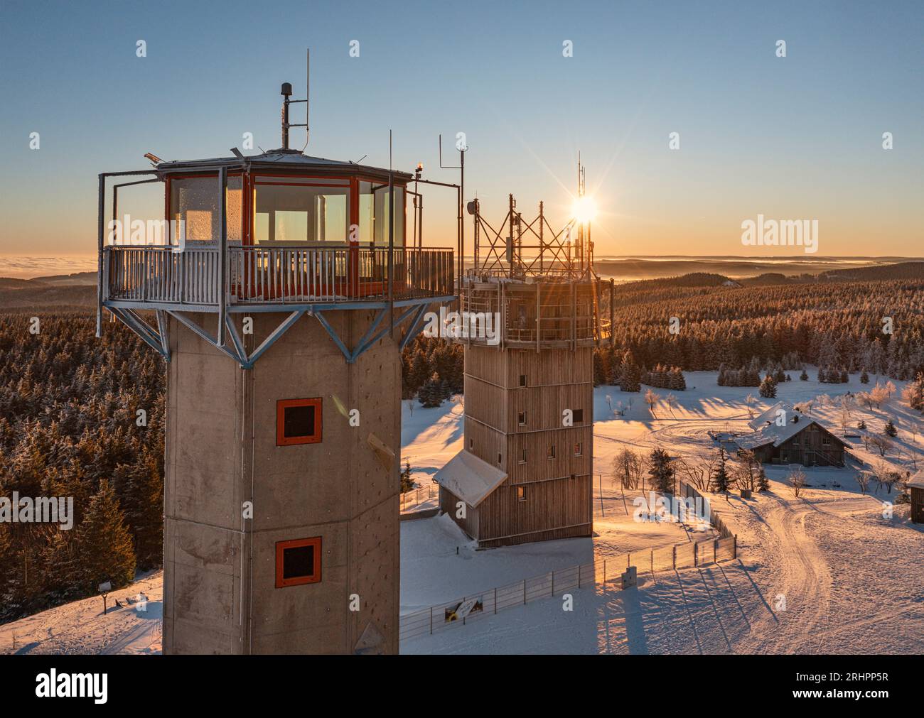Germany, Thuringia, Suhl, Gehlberg, Schneekopf (second highest mountain of the Thuringian Forest), observation and climbing tower, telecommunication tower, New Gehlberg Hut, forest, mountains, snow, sunrise, back light Stock Photo