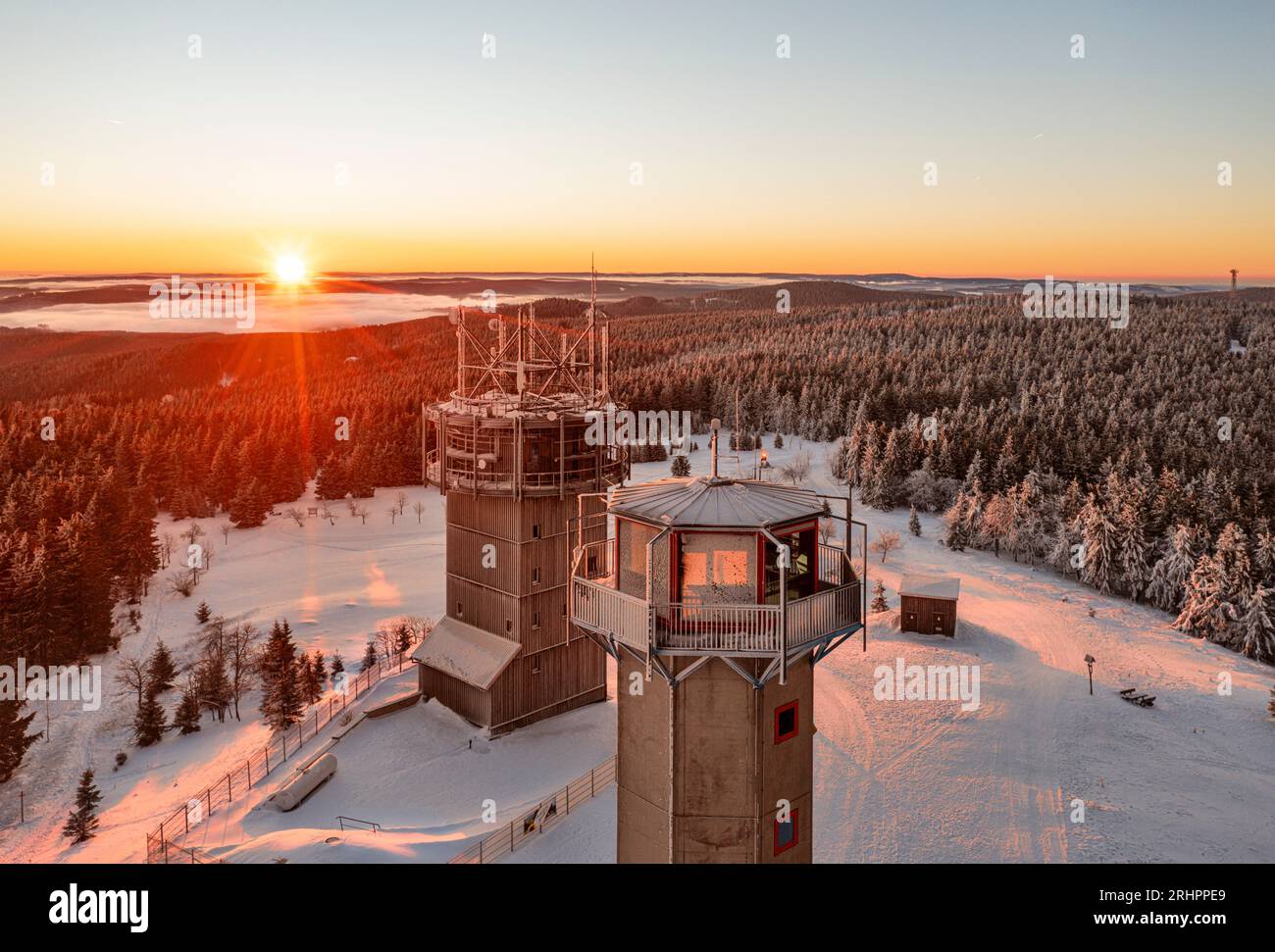 Germany, Thuringia, Suhl, Gehlberg, Schneekopf (second highest mountain of Thuringian Forest), observation and climbing tower, telecommunications tower, restaurant, forest, mountains, snow, sunrise, backlight, overview Stock Photo