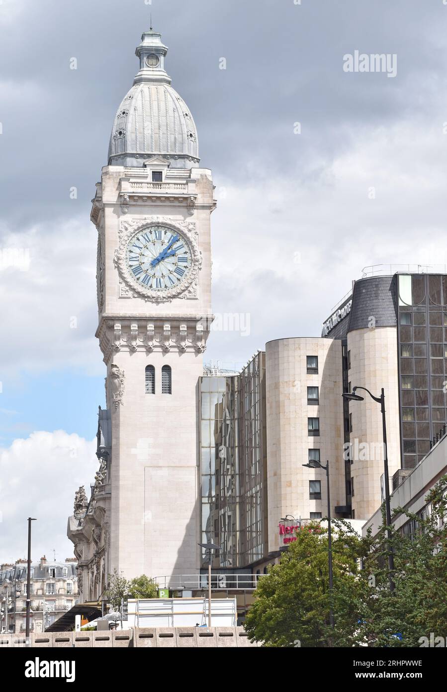The famous, elaborately decorated clock tower of the Gare de Lyon, Paris, built for the PLM Co., built 1891-1902, spoiled by new hotel building Stock Photo