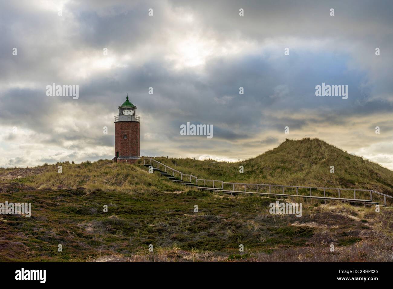 Lighthouse 'Quermarkenfeuer Rotes Kliff' near Kampen on Sylt with dramatic cloud cover Stock Photo