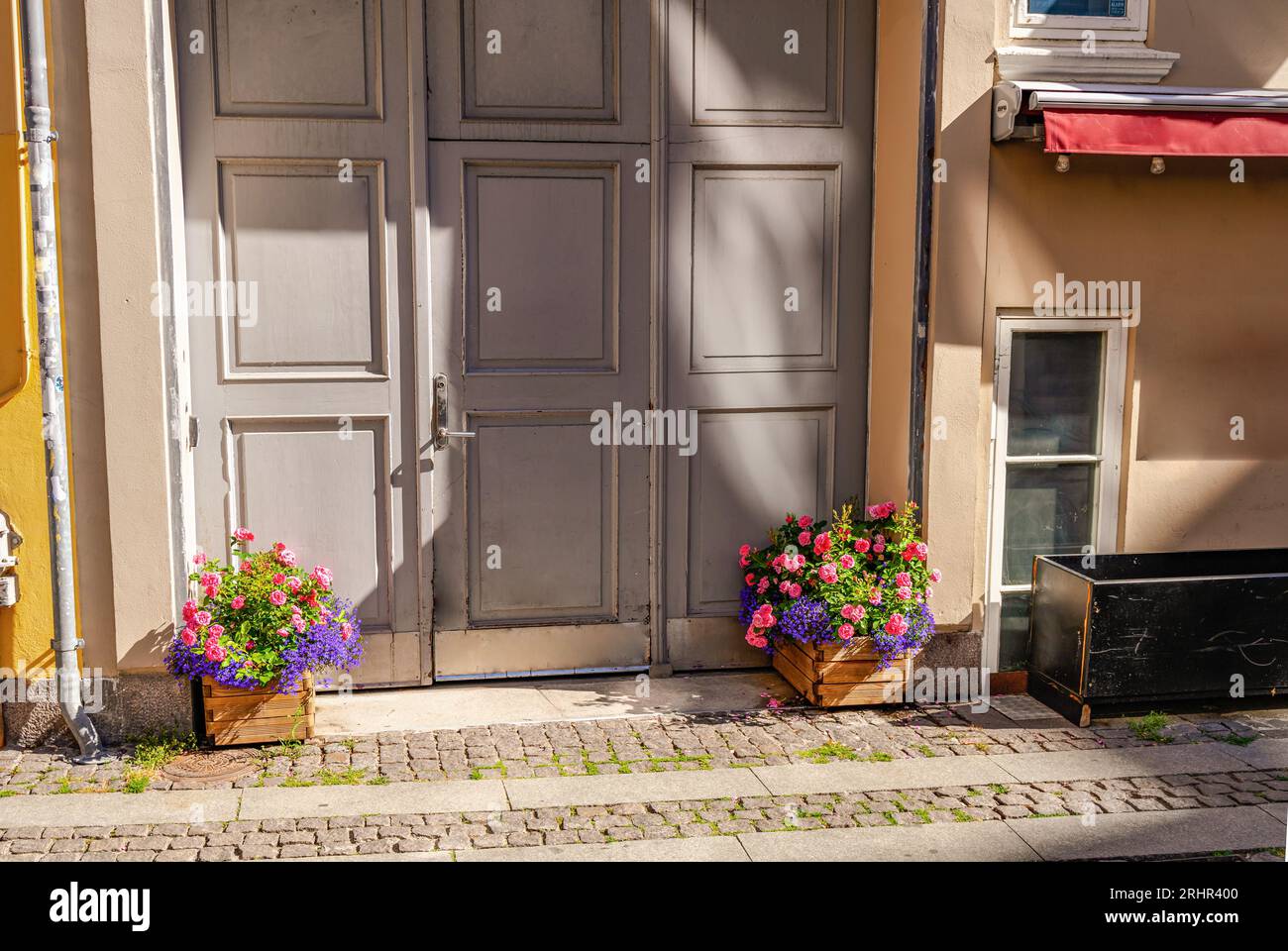 Antique front door and paving stone pavement with flower pots Stock ...