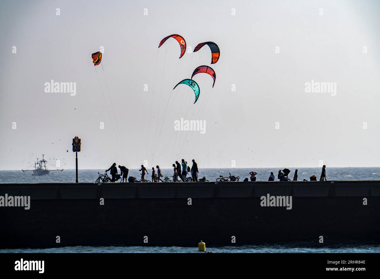 Kitesurfers off the coast of Scheveningen, strollers on the pier, The Hague, Netherlands Stock Photo