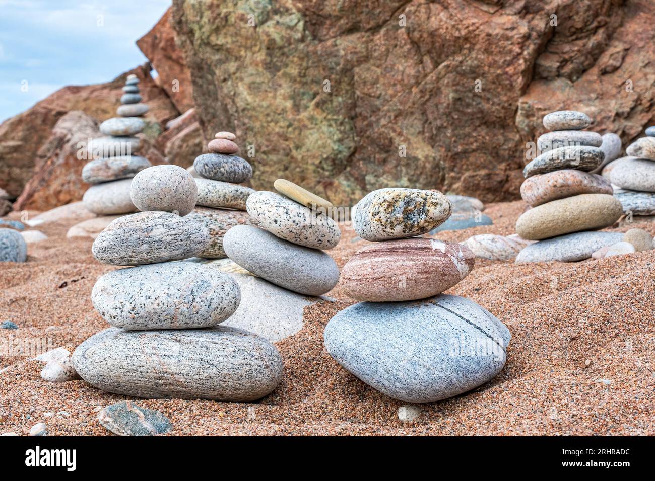 Rocks beautifully rounded by the ocean stacked making impromptu art on the beach in Pleasant Bay Nova Scotia. Stock Photo