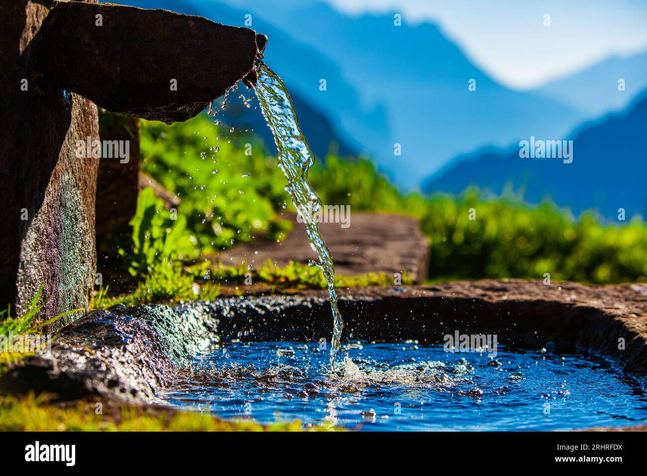 Water spring on Alps mountains background Stock Photo