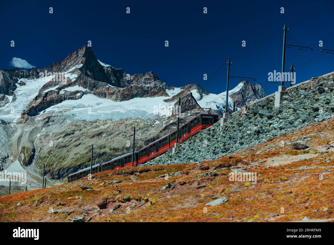 Red train in high Alps mountains Stock Photo