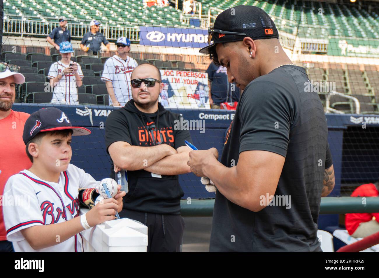 San Francisco Giants' third baseman Johan Camargo, right, autographs a