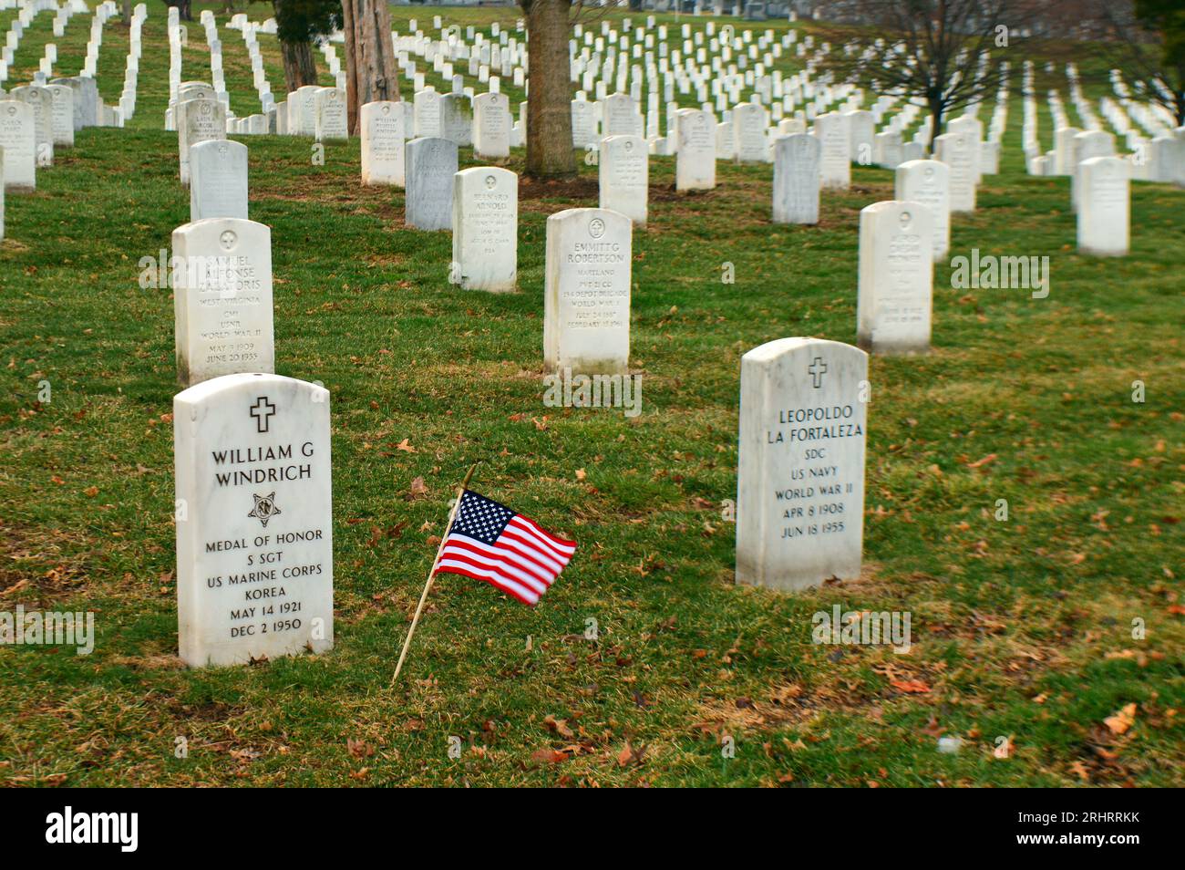 A small American flag waves amongst the numerous graves of deceased veterans at Arlington National Cemetery, near Washington DC Stock Photo