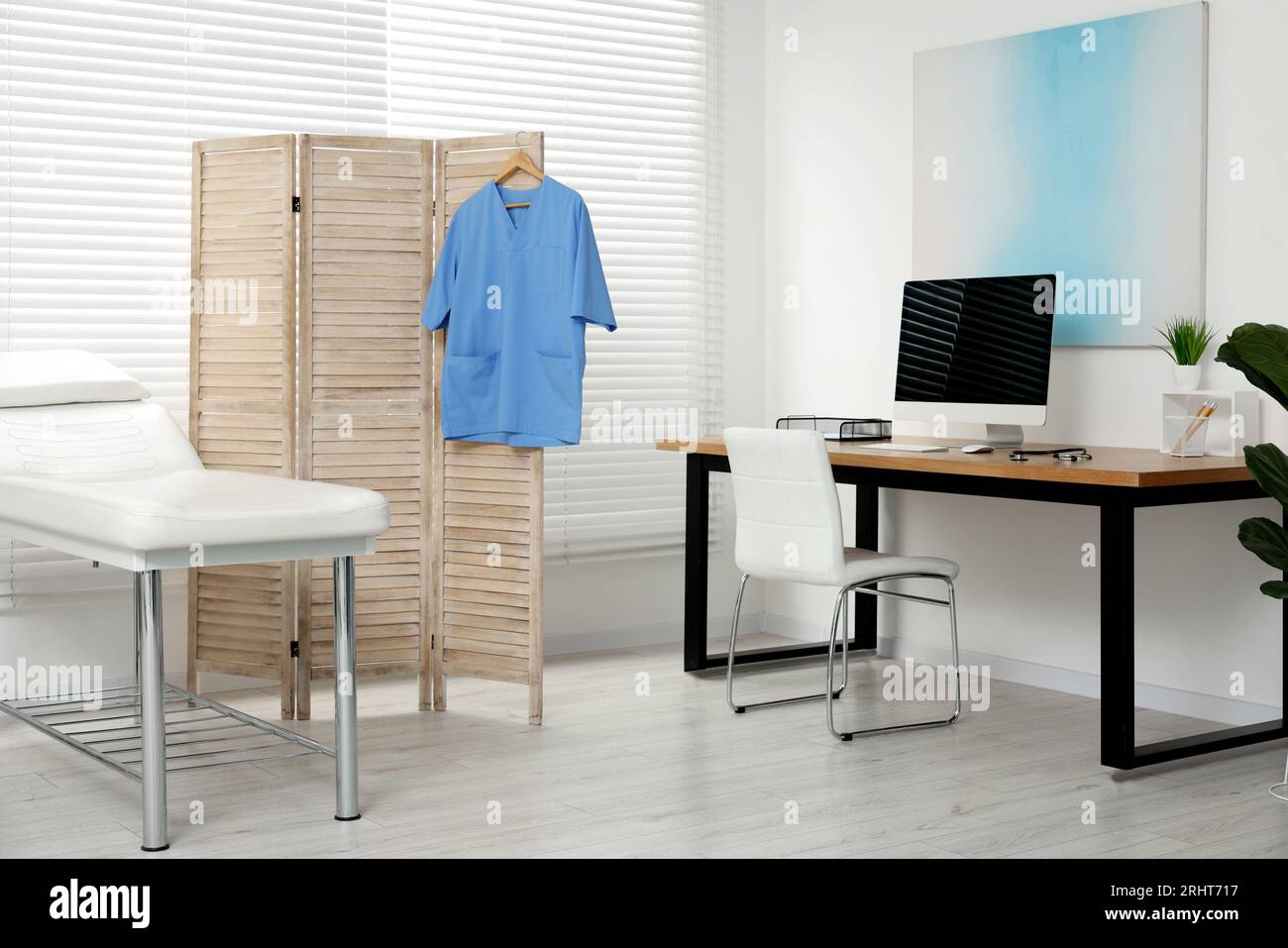 Modern medical office with doctor's workplace and examination table in ...