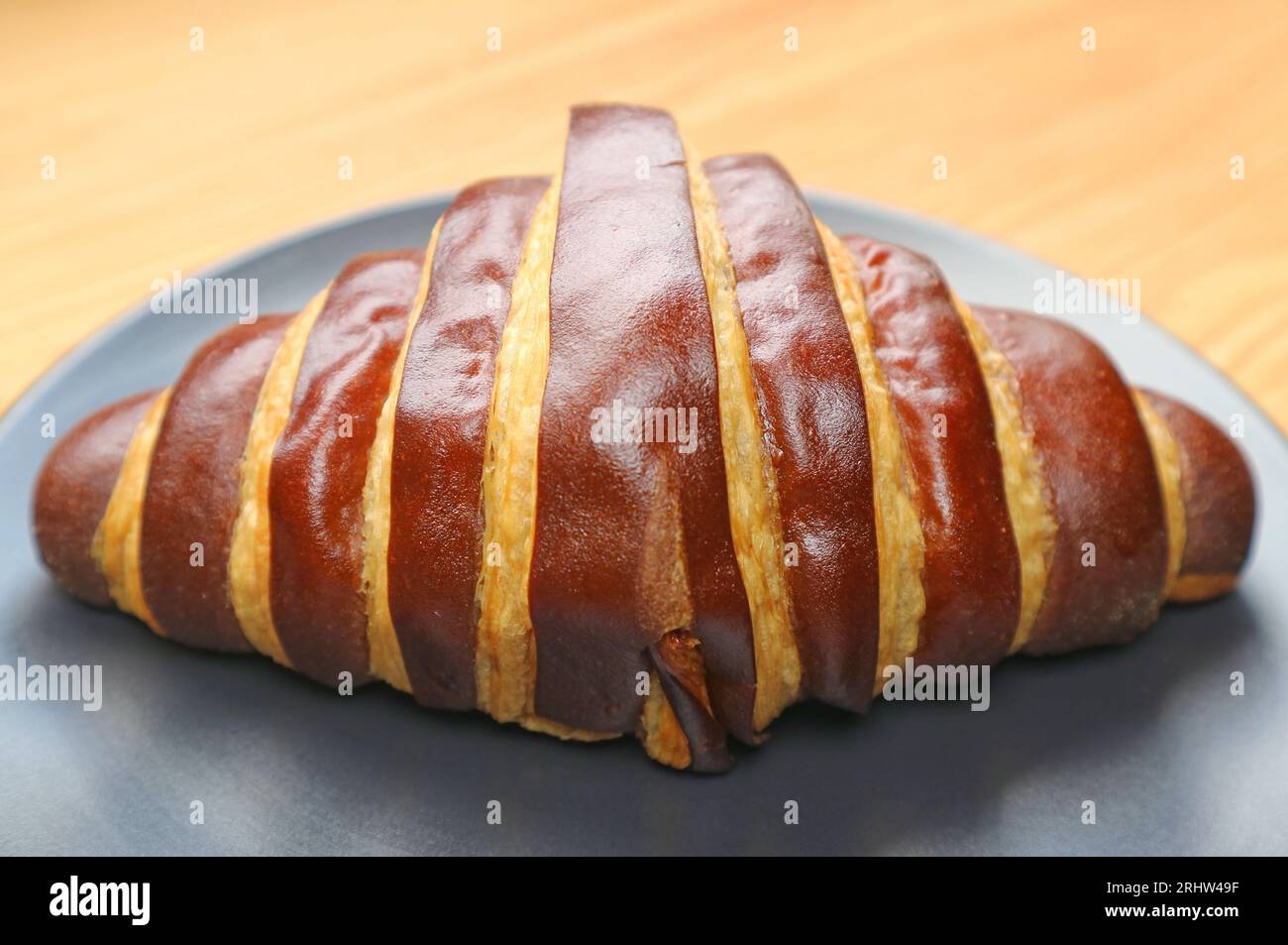 Closeup of a Delectable Bicolored Chocolate Croissant Served on Wooden Table Stock Photo