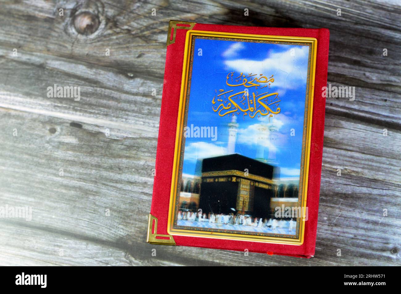 Makkah al-Mukarramah or Mecca the honored Quran  textbook, with a blurry glowing picture of Al Masjid Al Haram with Kaaba and minarets, Central book o Stock Photo