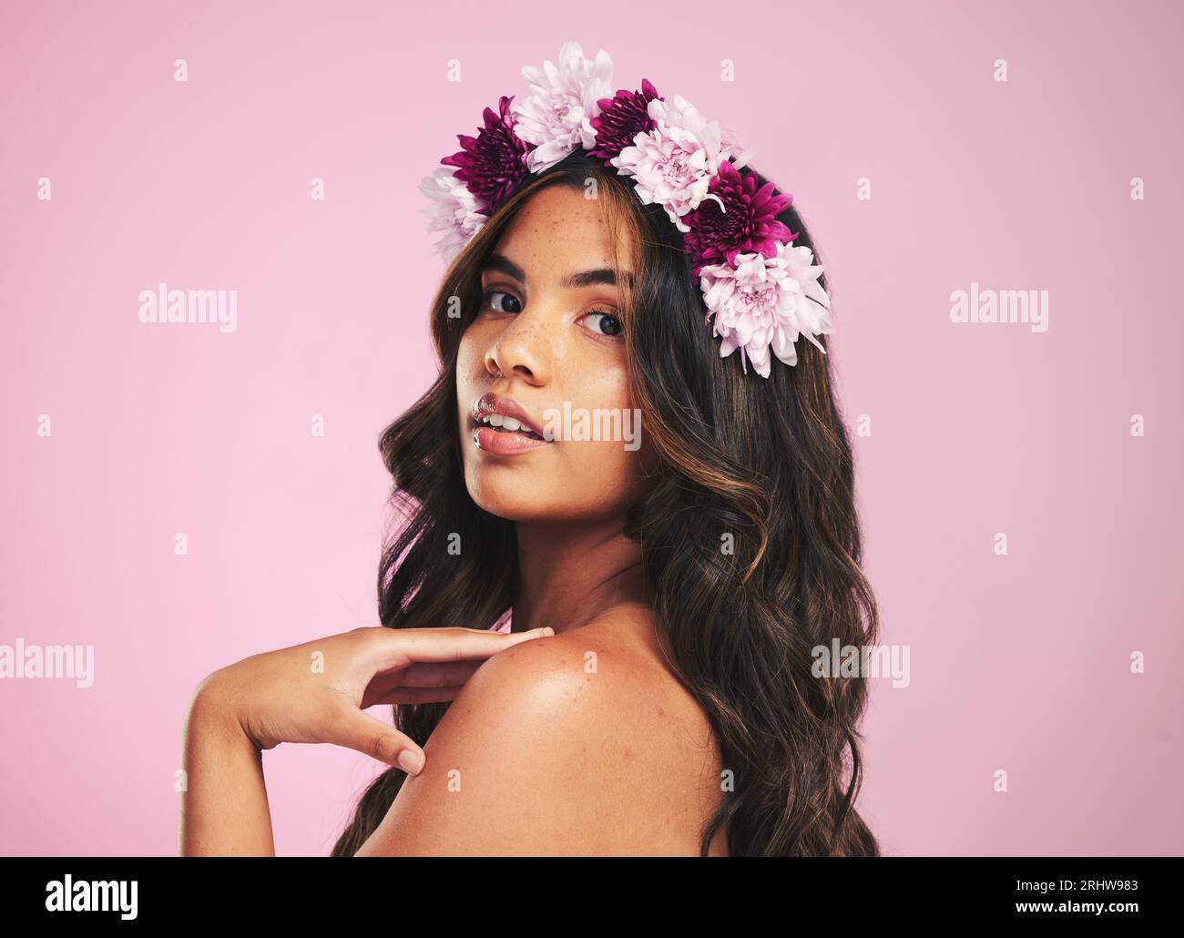 Woman, flowers and portrait of crown in studio for beauty, natural skincare and spring plants on pink background. Face, model and floral wreath for Stock Photo