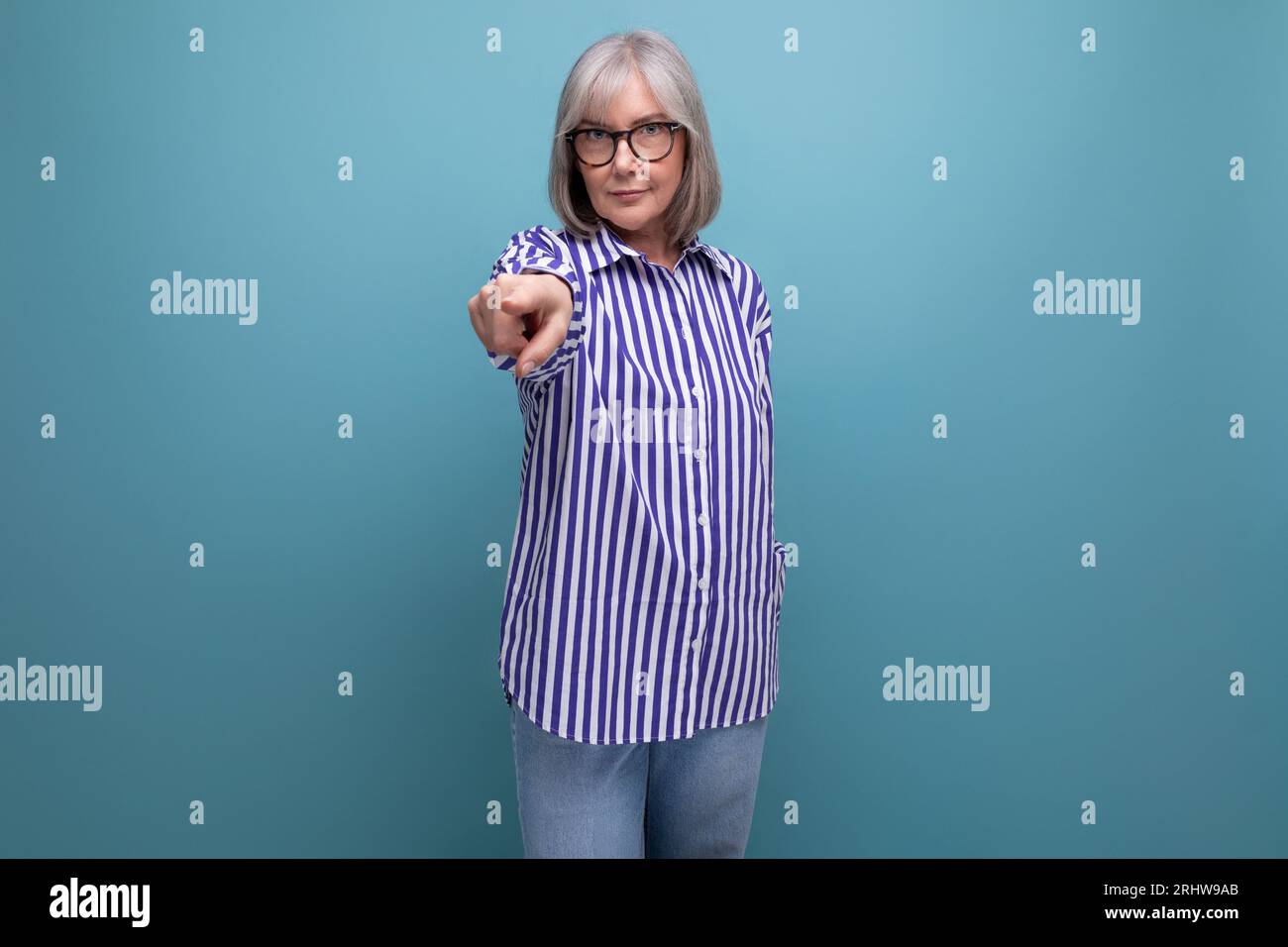 smart brilliant middle-aged lady with gray hair on a bright studio background with copy space Stock Photo