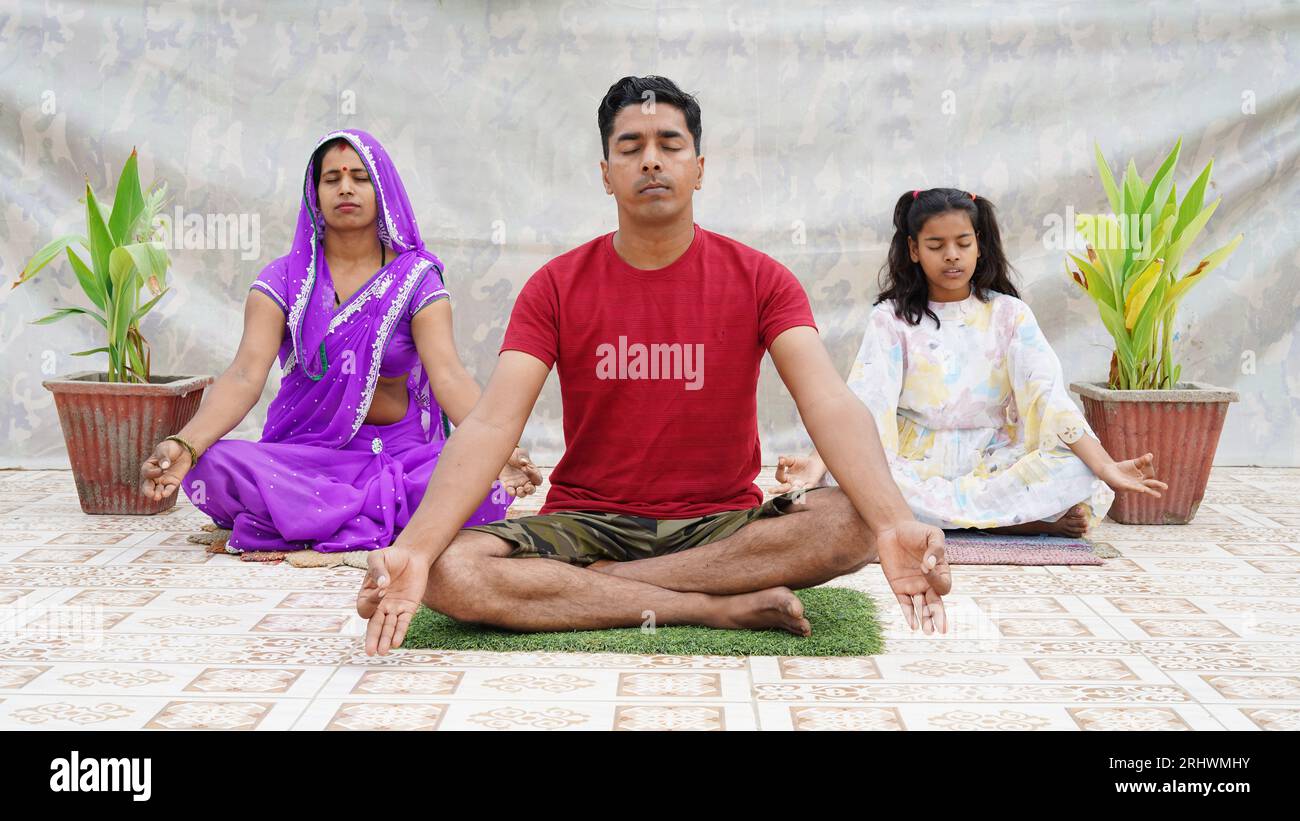 indian family doing meditation on the floor. Good life habit, healthy lifestyle, yoga practice with children at home Stock Photo