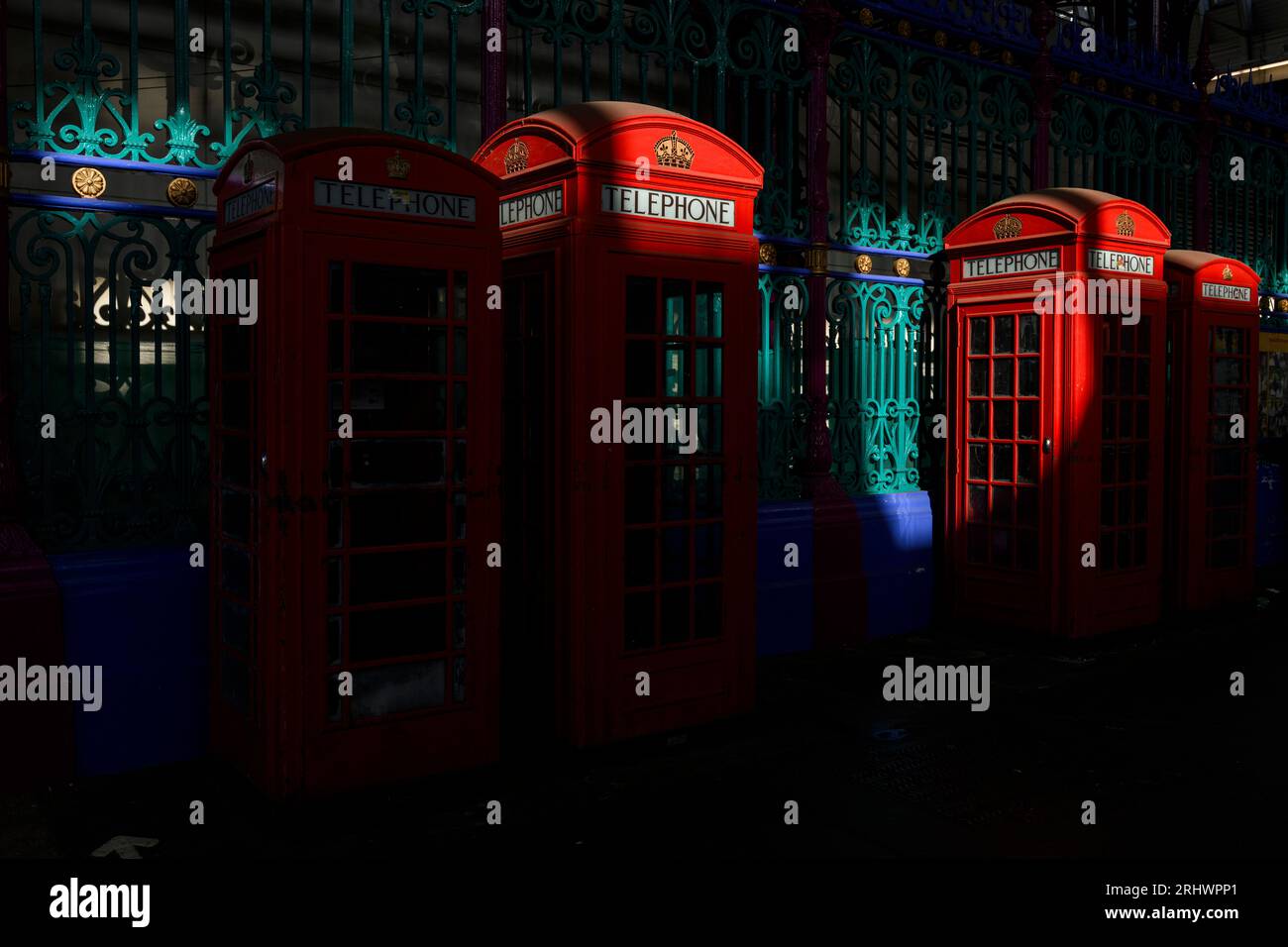 A row of four historic red phone boxes in Smithfield Meat Market - two smaller of them are K6 design and the other two are the K2 design, both created Stock Photo