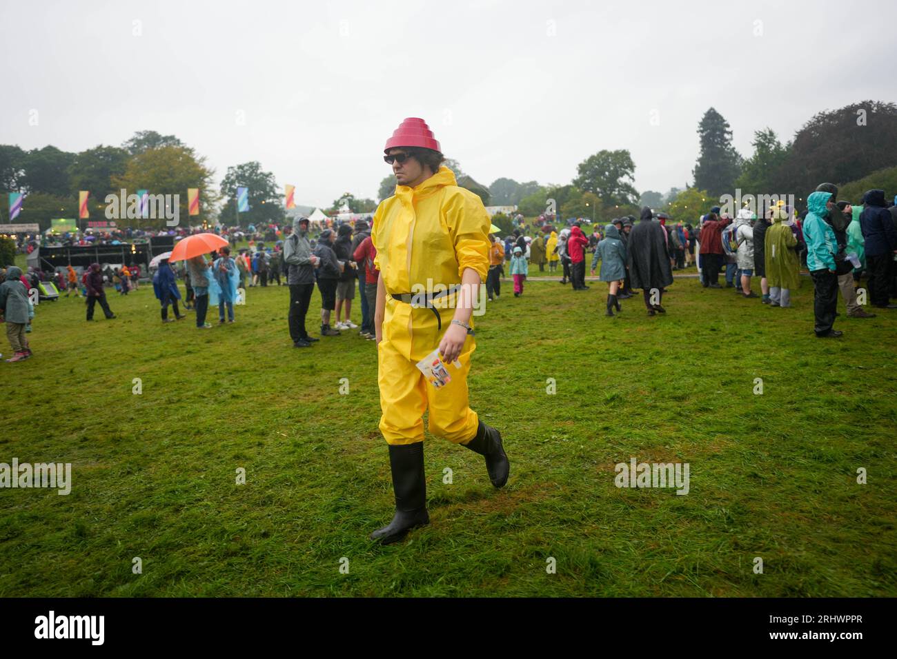 Glanusk Park, UK. Friday, 18 August, 2023. A festival goer dressed for the Devo performance on a rainy day 2 at the 2023 Green Man Festival in Glanusk Park, Brecon Beacons, Wales. Photo date: Friday, August 18, 2023. Photo credit should read: Richard Gray/Alamy Live News Stock Photo