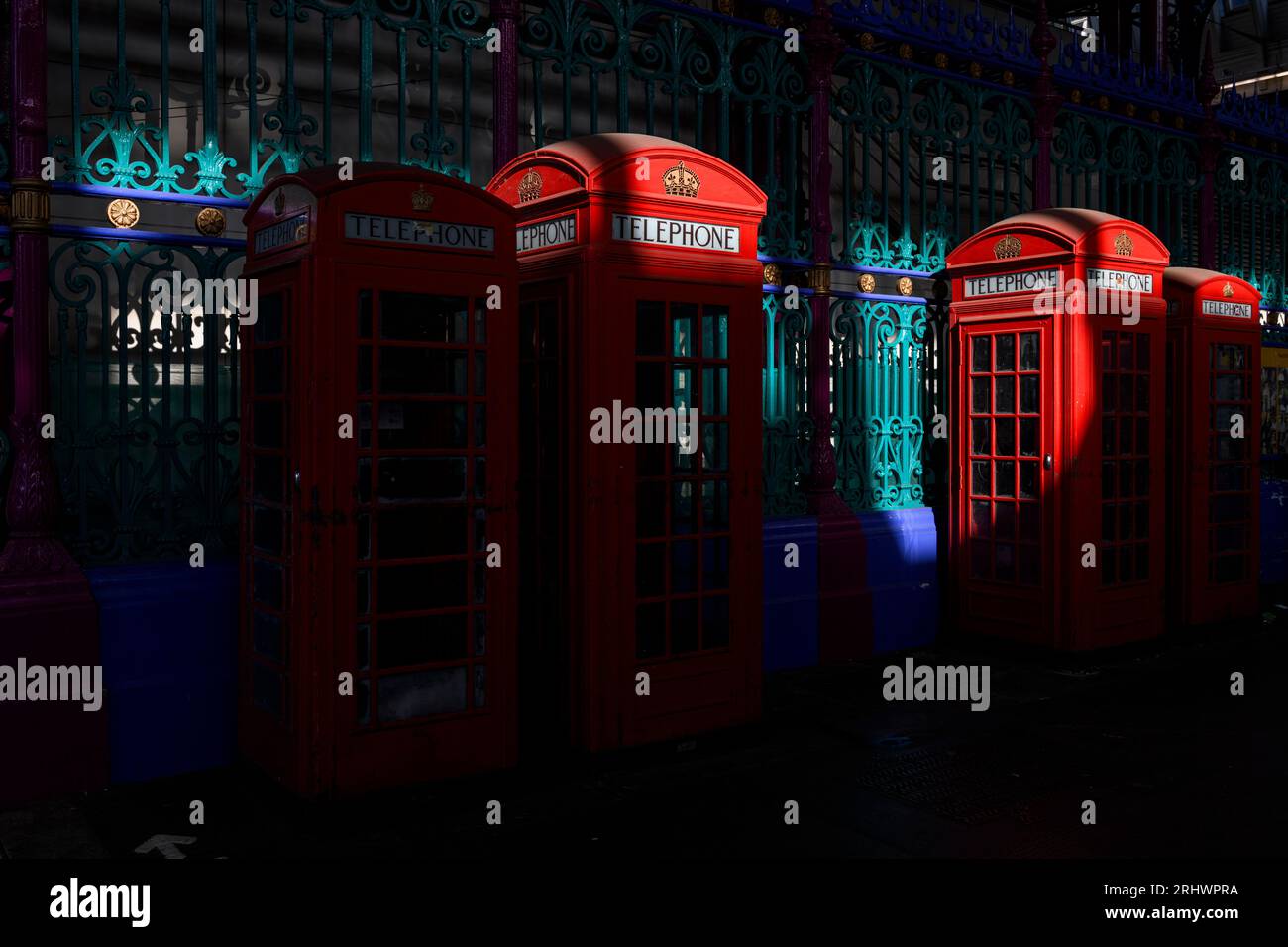 A row of four historic red phone boxes in Smithfield Meat Market - two smaller of them are K6 design and the other two are the K2 design, both created Stock Photo