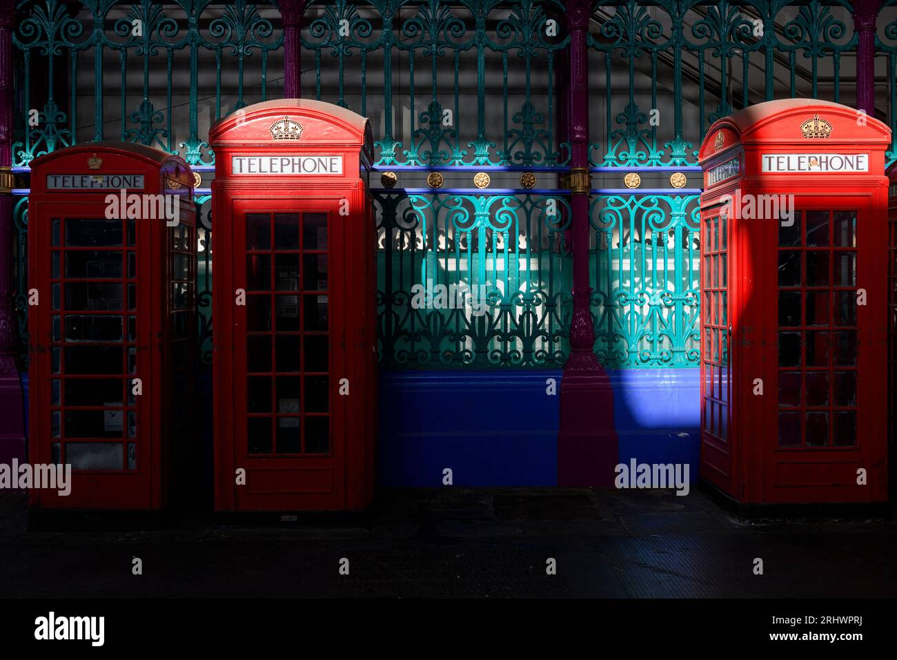 A row of three historic red phone boxes in Smithfield Meat Market - the smaller of them is the K6 design and the other two are the K2 design, both cre Stock Photo