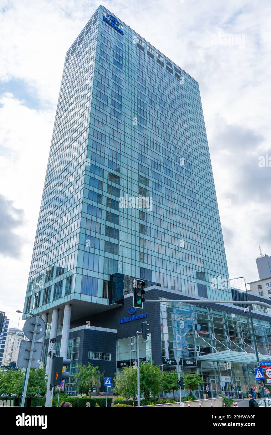 The building and logo of the Polish hotel Hilton Warsaw. Office building skyscraper in the city center. Entrance facade. Warsaw, Poland - July 26, 2023. Stock Photo