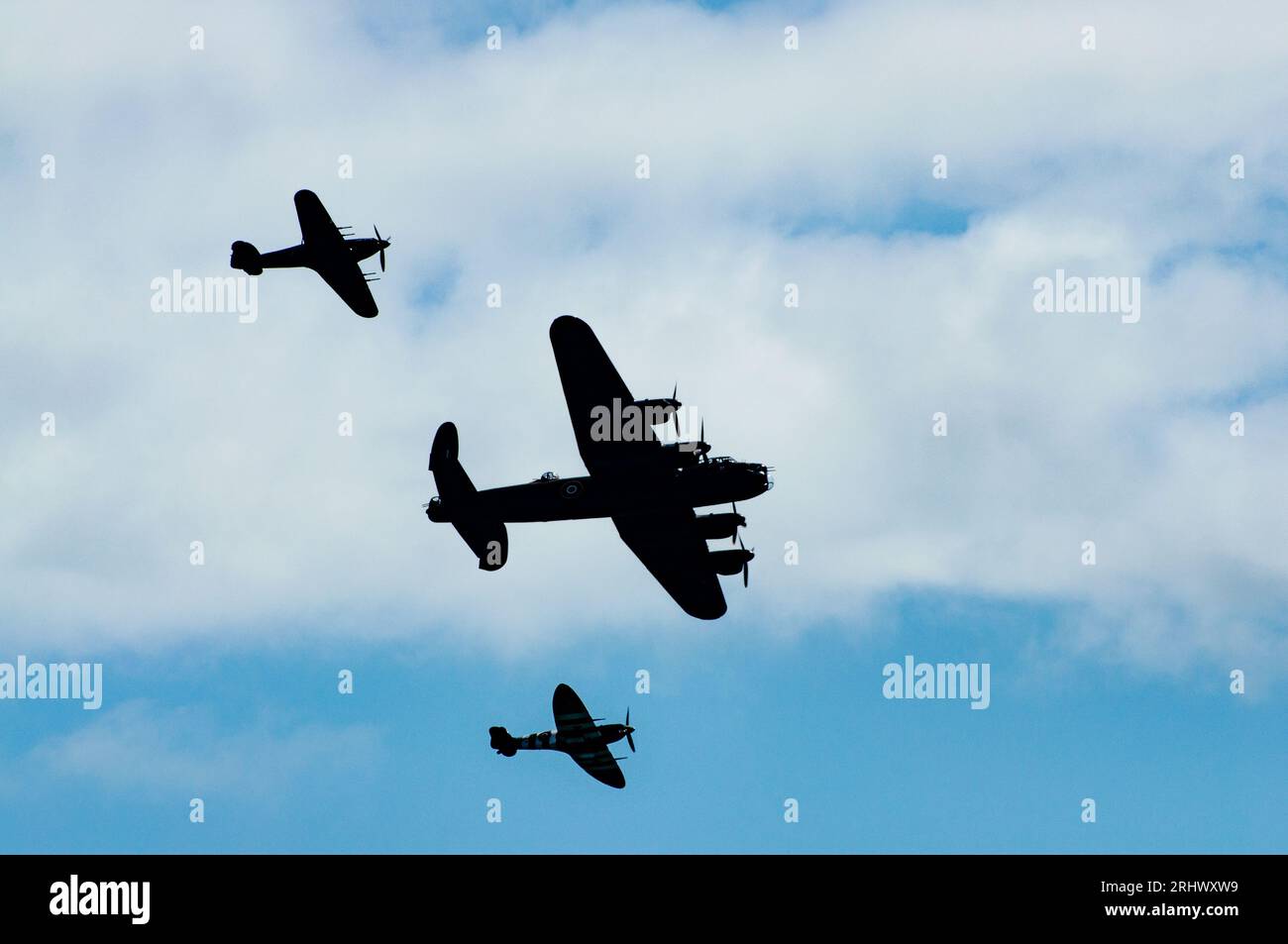 Eastbourne, UK. 19 Aug 2023. The Battle of Britain Memorial Flight comprising WW2-era Lancaster, Spitfire and Hurricane are seen in silhouette as they fly past the seafront at the annual Eastbourne Airbourne, an international airshow. The show runs for four days with flying displays along the seafront. Credit: Andy Soloman/Alamy Live News Stock Photo