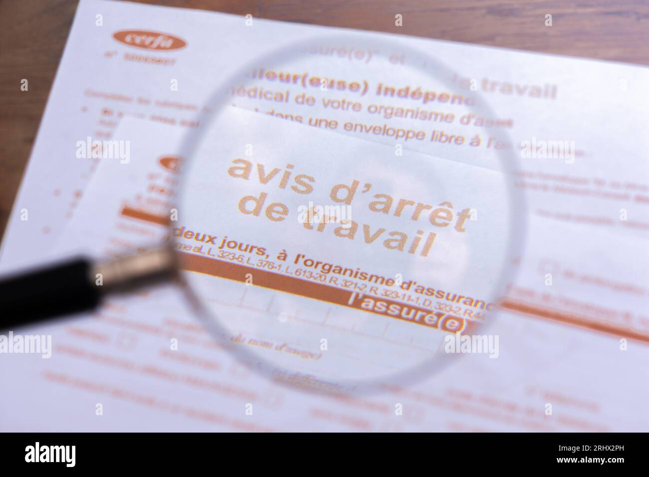 France: Close-up through a magnifiying glass of an official sick leave form ('Avis d'arrêt de travail') from the French social security Stock Photo