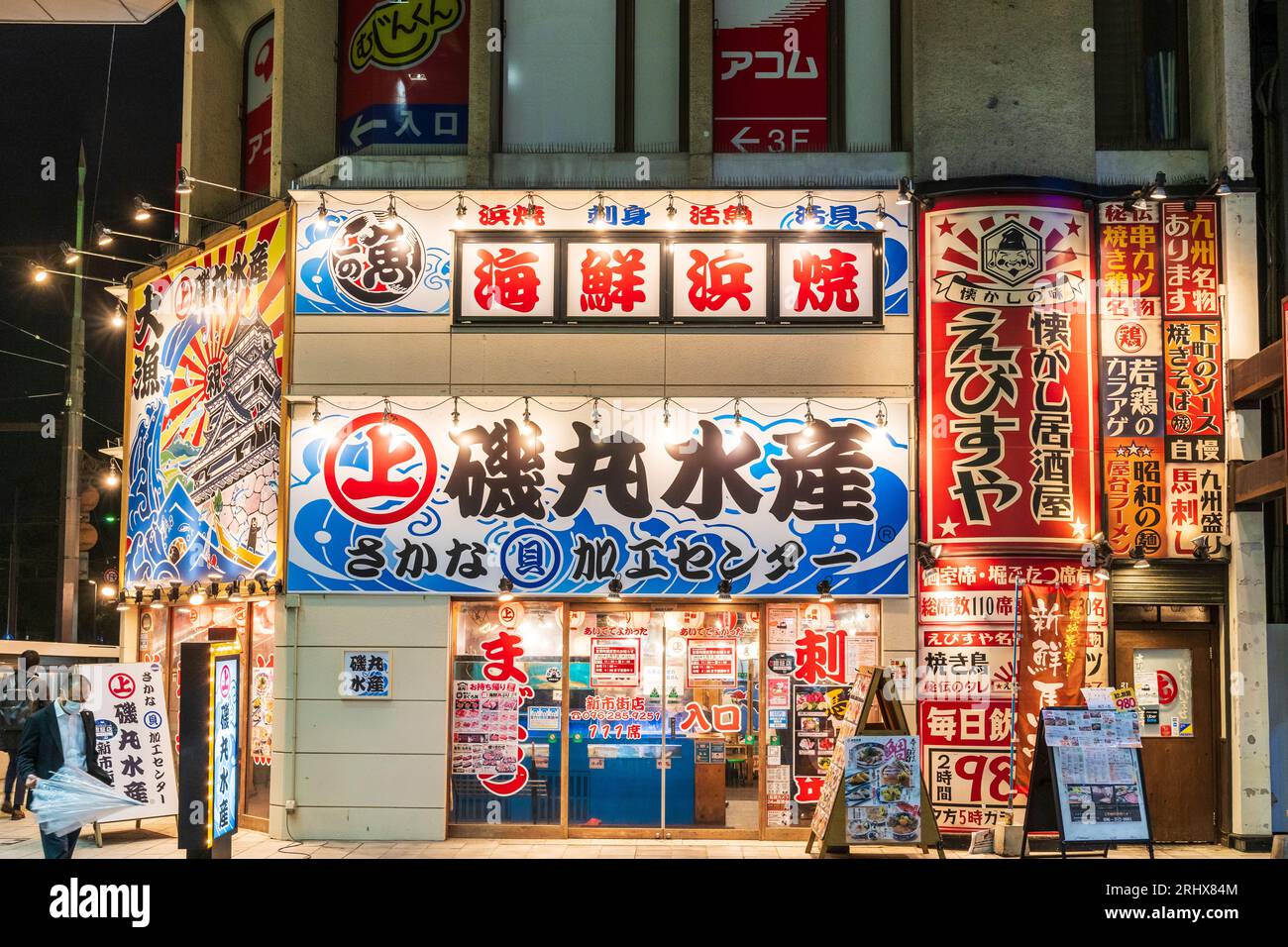 Front facade and entrance of a branch of the popular Mekiki no Ginza seafood chain restaurant in Shimotori shopping arcade in Kumamoto in the evening. Stock Photo