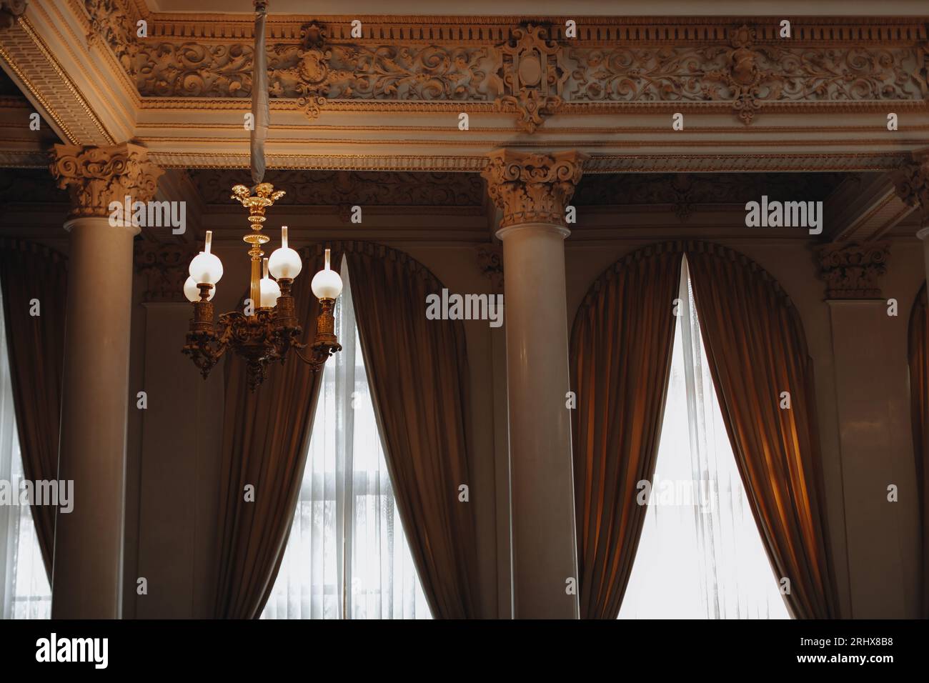 Vintage brown gold interior with marble columns and royal chandelier. Aesthetics of historical architecture Stock Photo