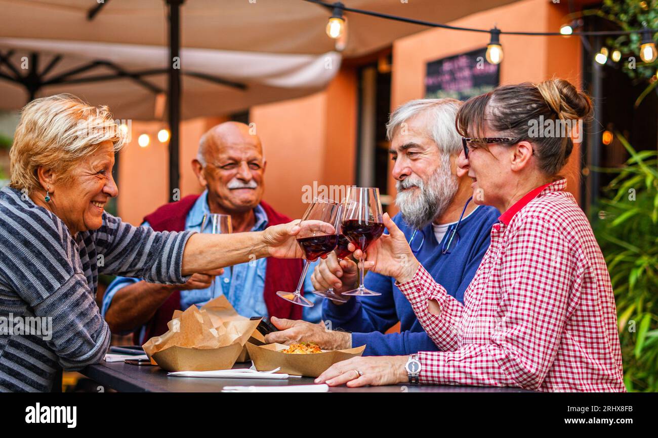 Elderly couples eat and drink together - Old friends have a reunion in a restaurant Stock Photo