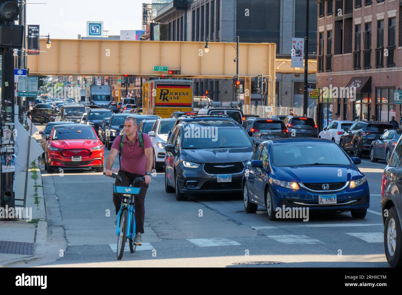 Bicyclist on rental bike in rush hour traffic on Halsted Street, Chicago, Illinois. Stock Photo