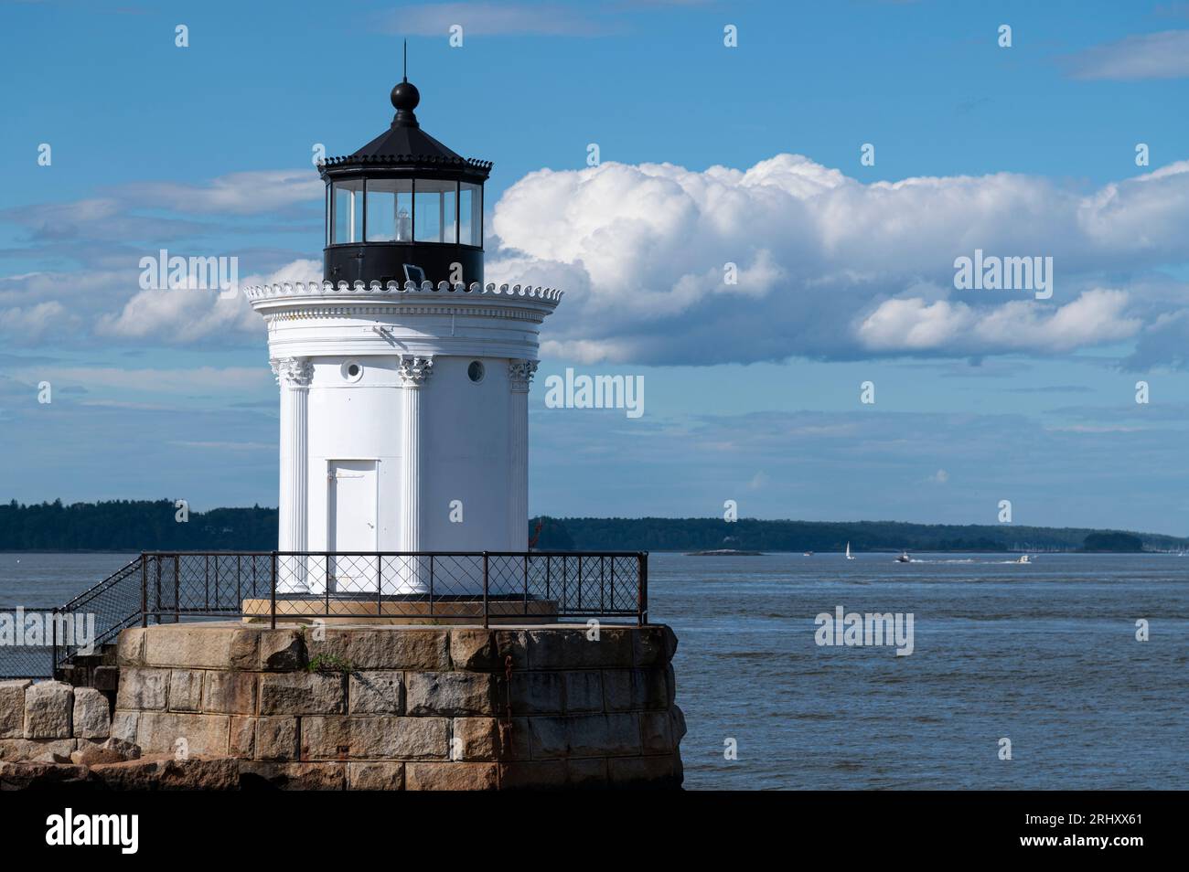 Portland Breakwater Lighthouse, also known as 'Bug Light' for its size, overlooks the entrance to Portland Harbor in Maine on a tranquil summer day. Stock Photo