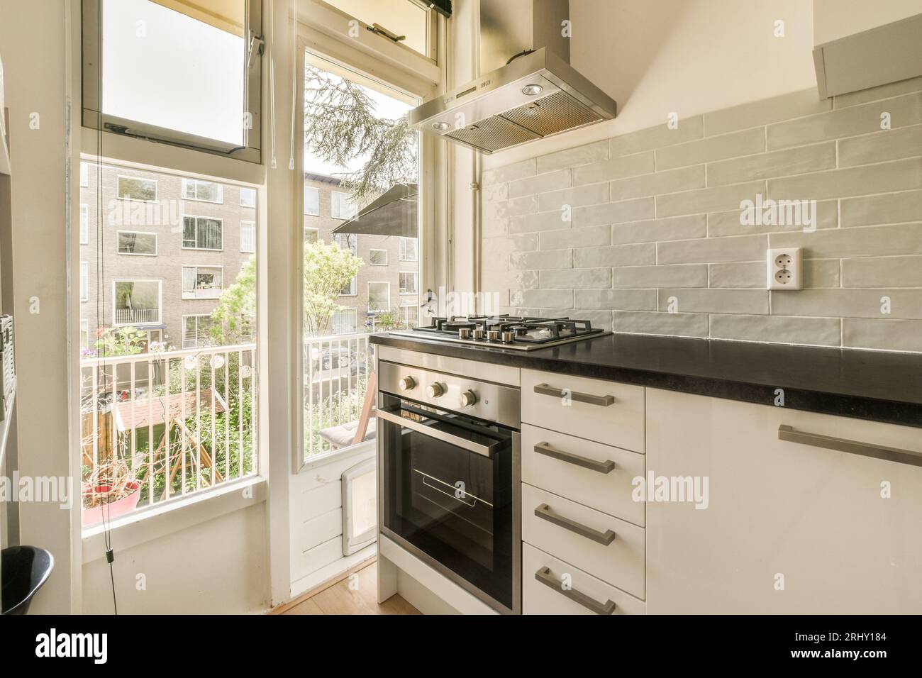 a kitchen with white cabinets and black counter tops in front of the ...