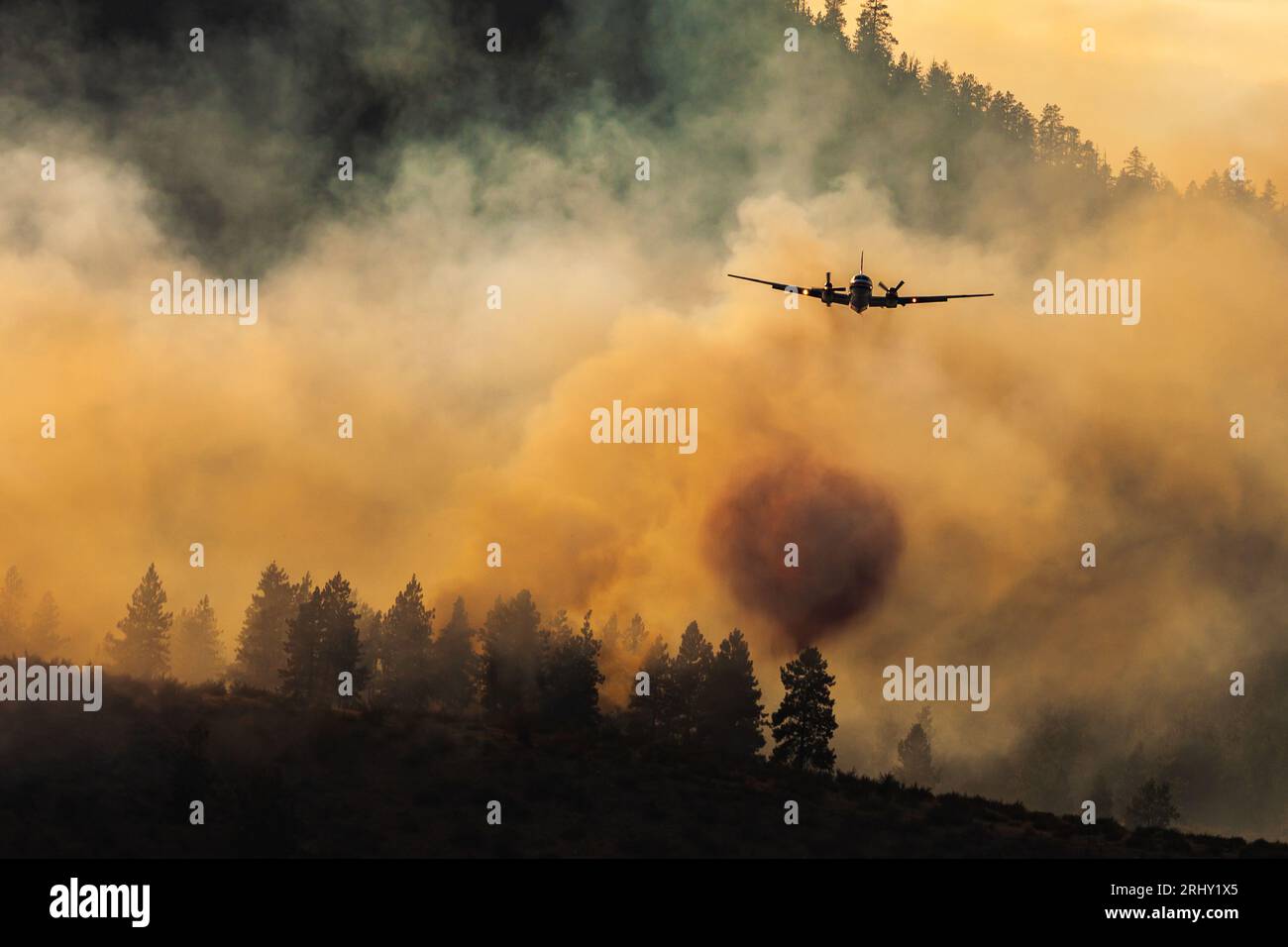 Fire fighting plane dropping retardant on Canadian wildfire. Stock Photo