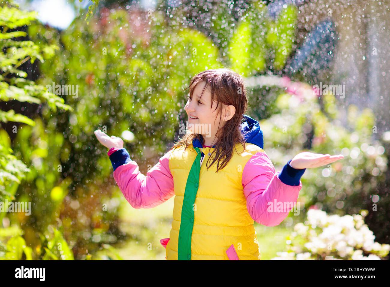 Child playing in autumn rain. Kid with umbrella. Little girl running in