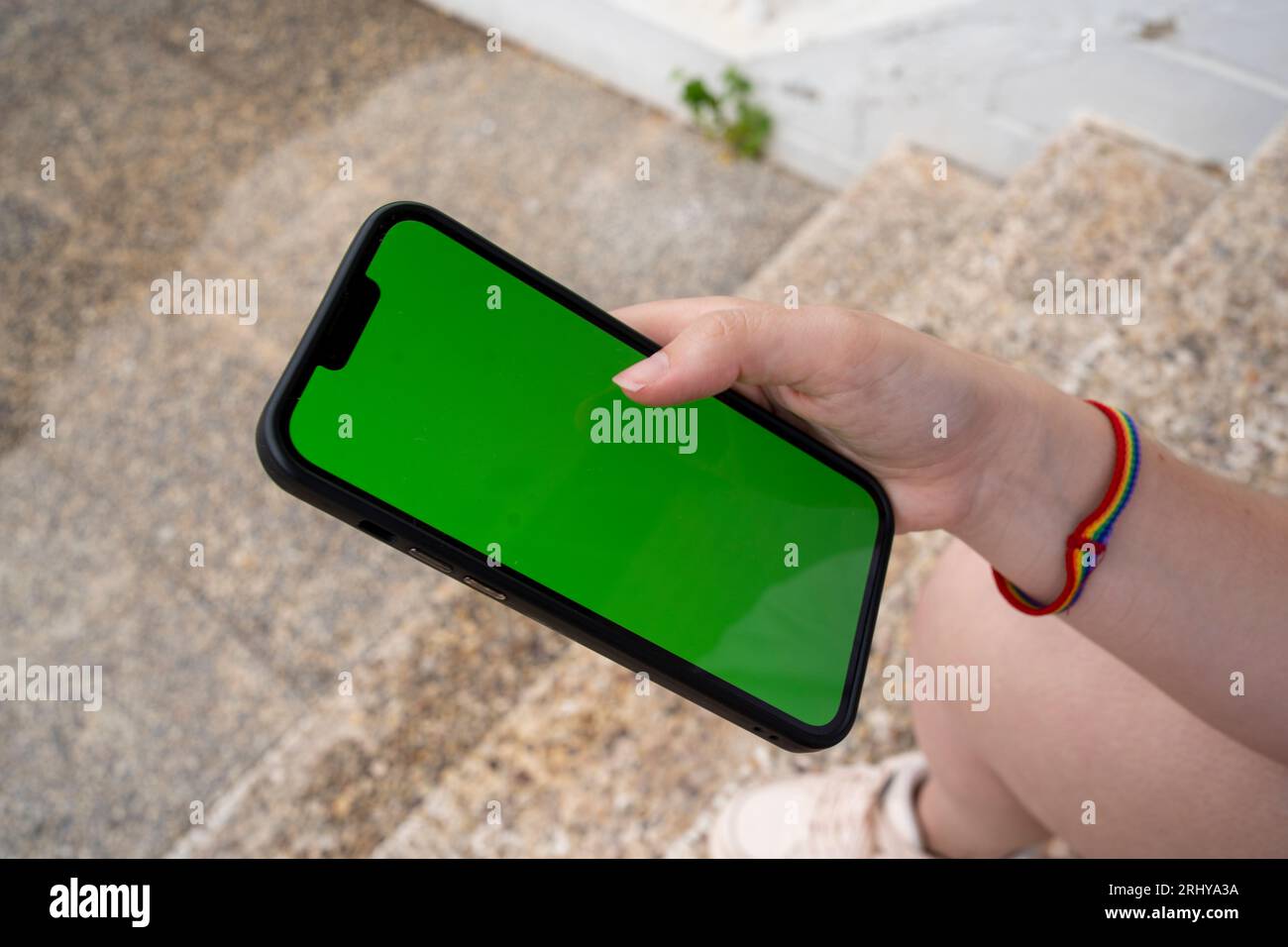 Unrecognizable young woman sitting and browsing smartphone Stock Photo