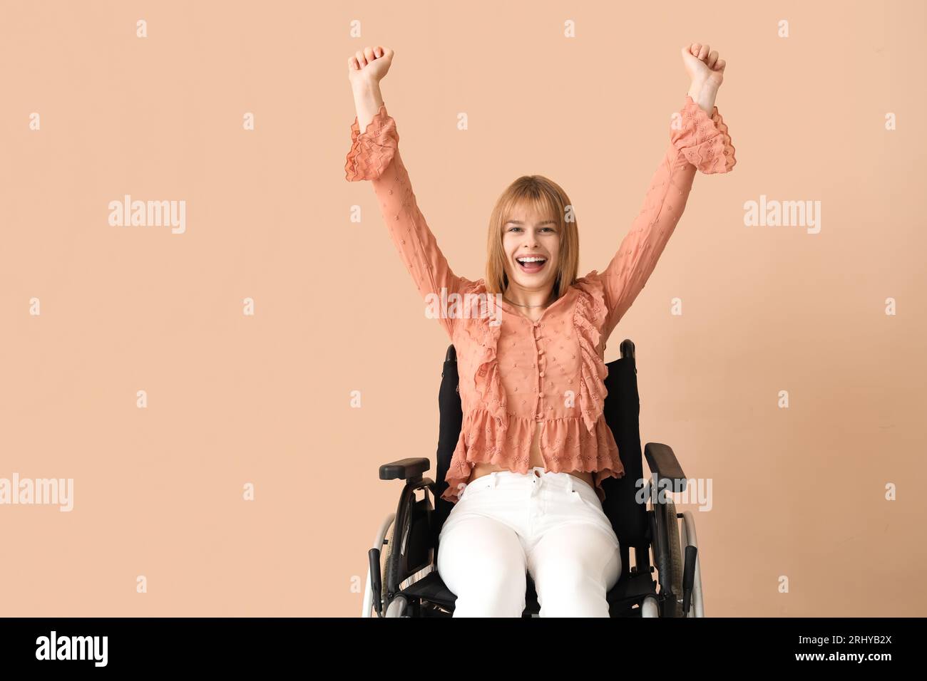 Happy young woman in wheelchair on beige background Stock Photo - Alamy