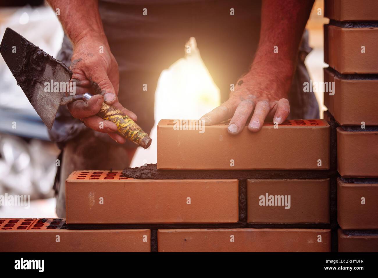 Builder laying bricks on construction site Stock Photo
