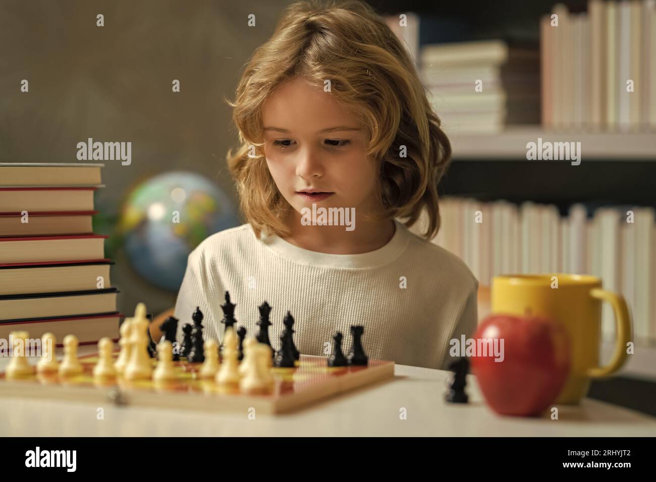 Concentrated child boy developing chess strategy, playing board game