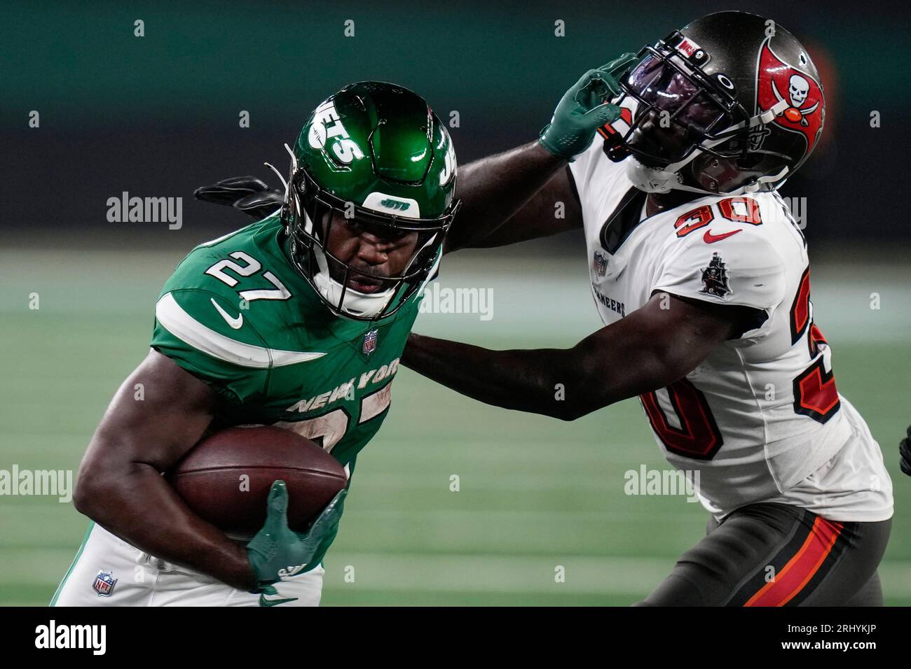 New York Jets running back Zonovan Knight (27) stiffarms Tampa Bay