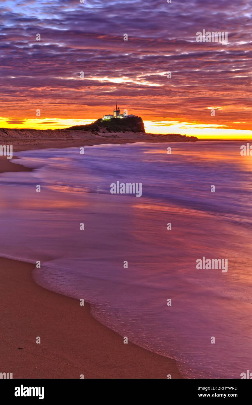 Scenic seascape sunrise over Nobbys head lighthouse tower in Newcastle city of Australia. Stock Photo