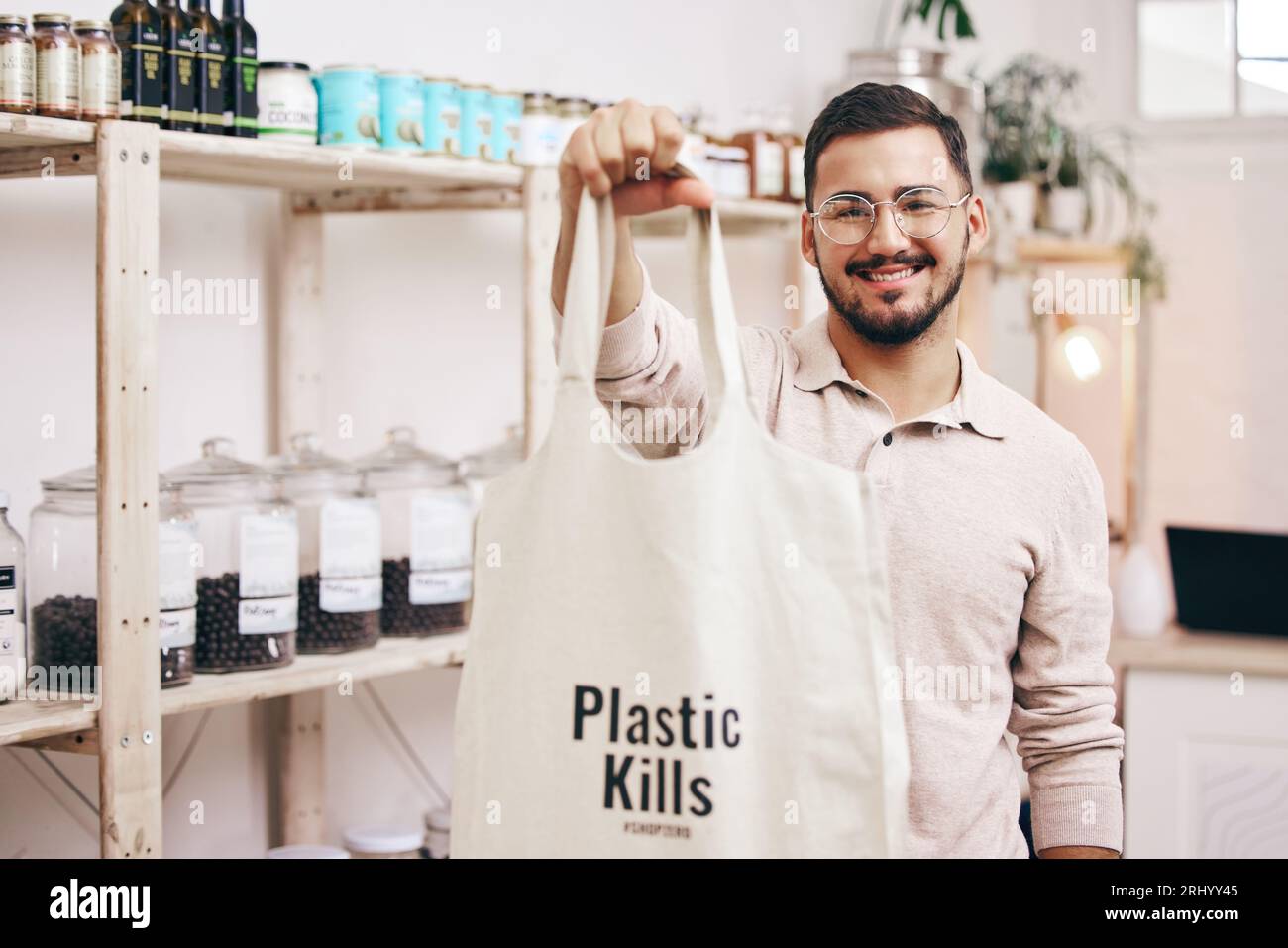 Man at eco friendly grocery store, recycling shopping bag and commitment to climate change at sustainable small business. Zero waste, plastic kills Stock Photo