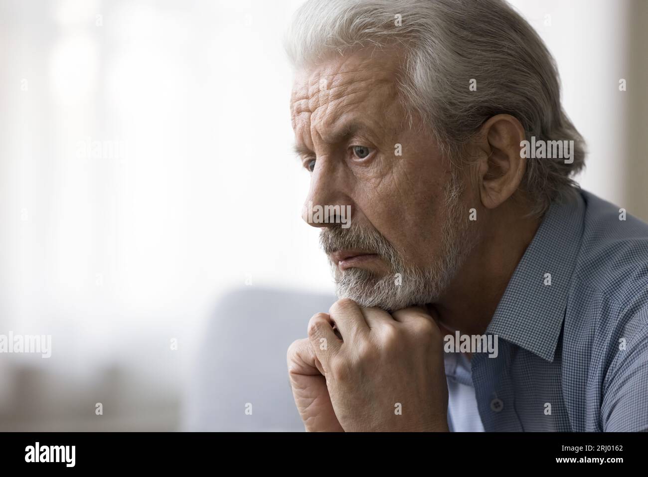 Concerned thoughtful older retired man looking away Stock Photo