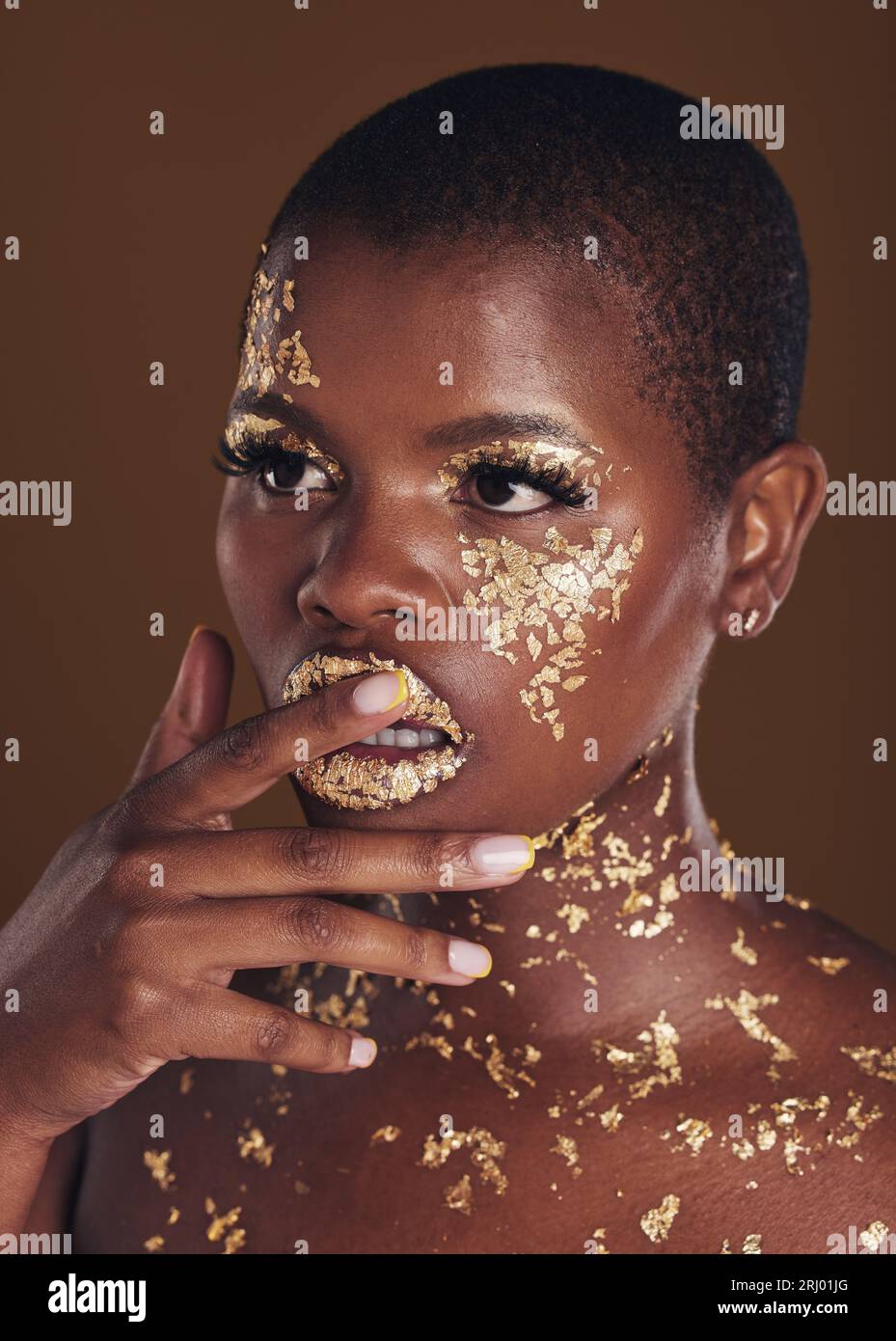 Gold, glitter flake and black woman beauty with makeup and luxury in studio  with sparkle cosmetics. Brown background, smile and female model with  golden paint for skin glow and creative facial shine