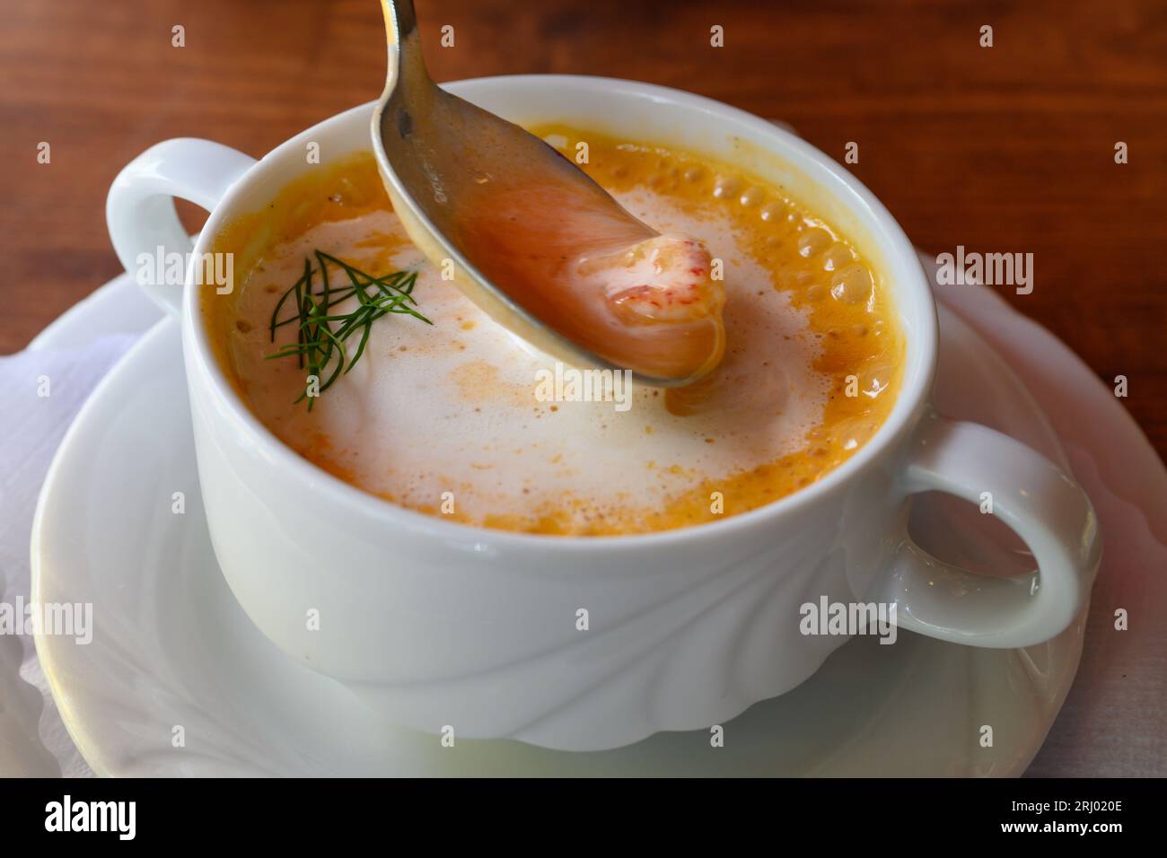 Busumer Krabbensuppe, Busom Style Soup with North Sea Crabs or Brown Shrimps on a Spoon in a White Bowl Stock Photo