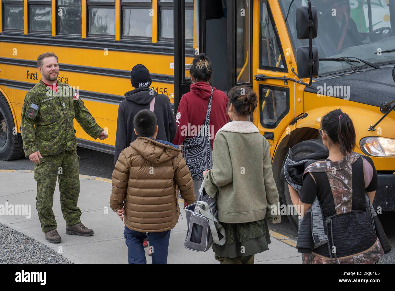 (230820) -- NORTHWEST TERRITORIES, Aug. 20, 2023 (Xinhua) -- A member of the Canadian Armed Forces directs people on to a bus destined for the Yellowknife airport in Yellowknife, Northwest Territories, Canada, on Aug. 18, 2023. The Canadian Armed Forces participated in an evacuation operation, helping residents out of Yellowknife as wildfires approached the city. (Canadian Armed Forces/Handout via Xinhua) Stock Photo