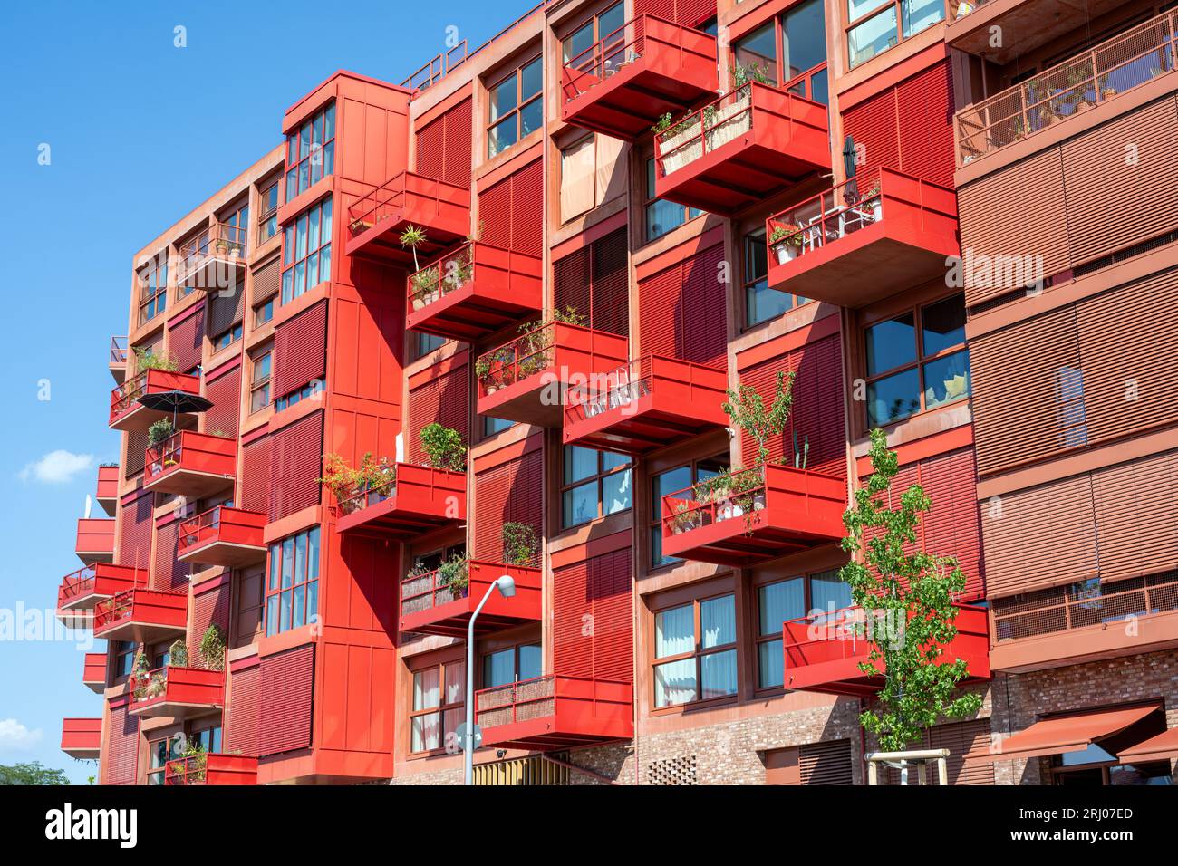 Red apartment building with balconies seen in Berlin, Germany Stock Photo