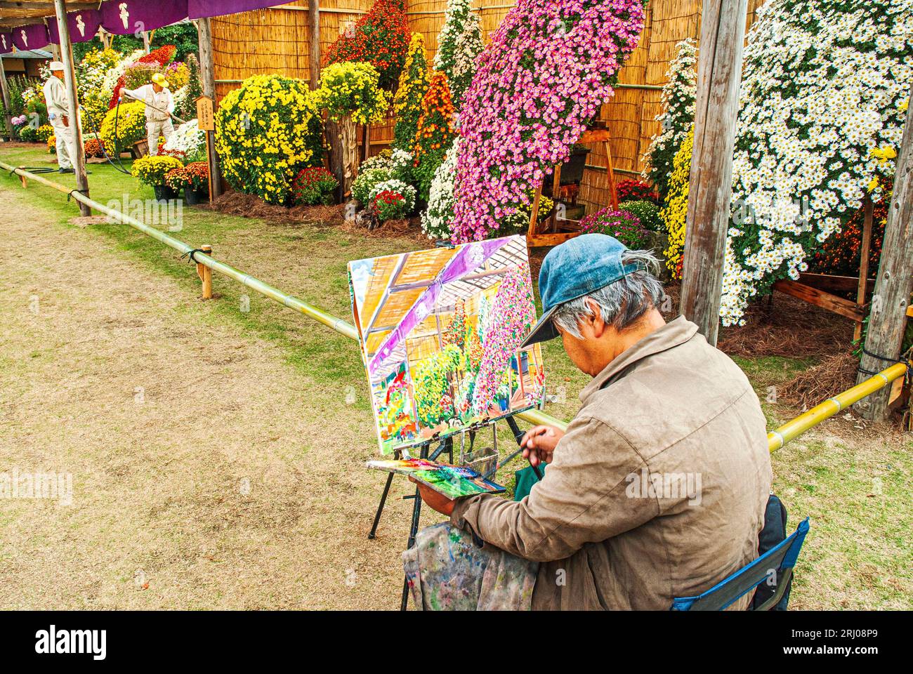 An artist painting a picture of a chrysanthemum presentation. Stock Photo