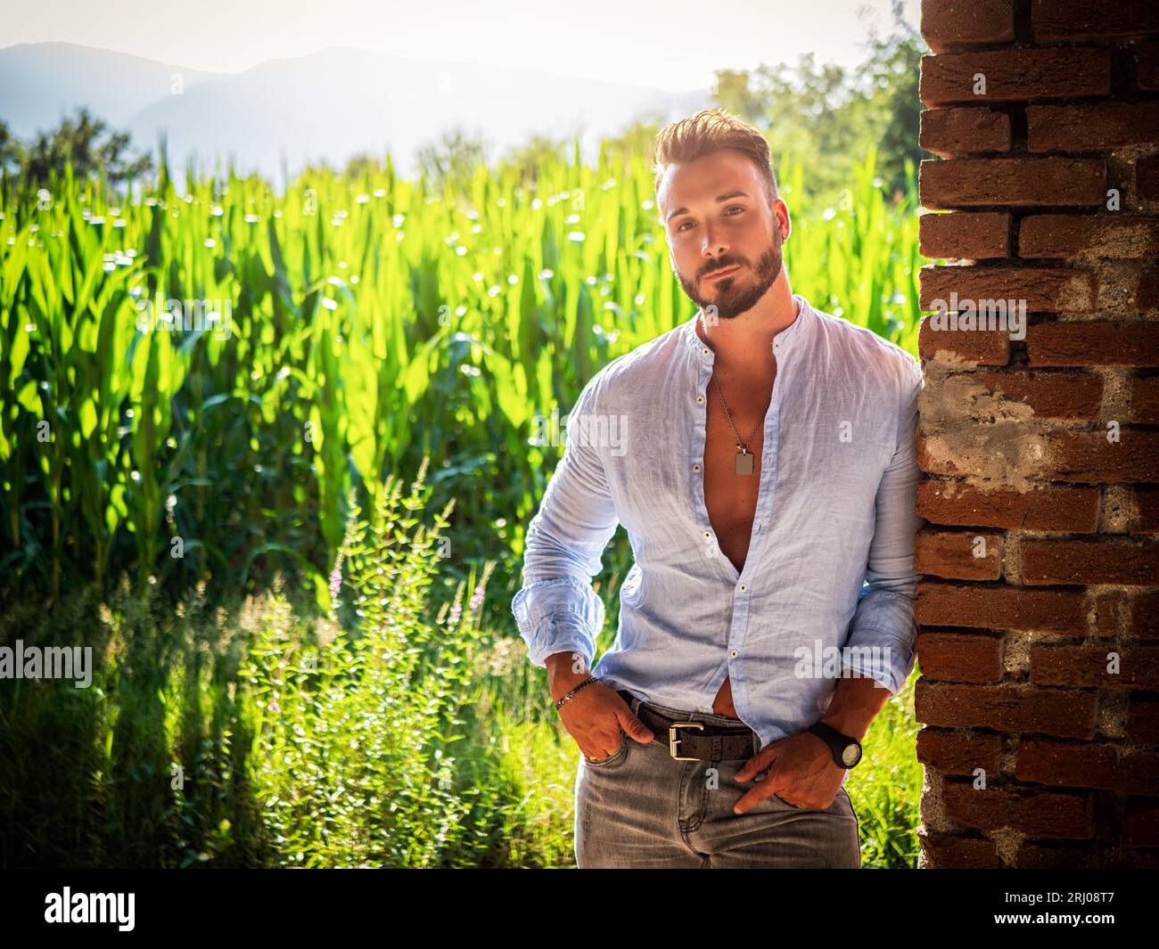 Photo of a man standing in front of a brick wall Stock Photo - Alamy