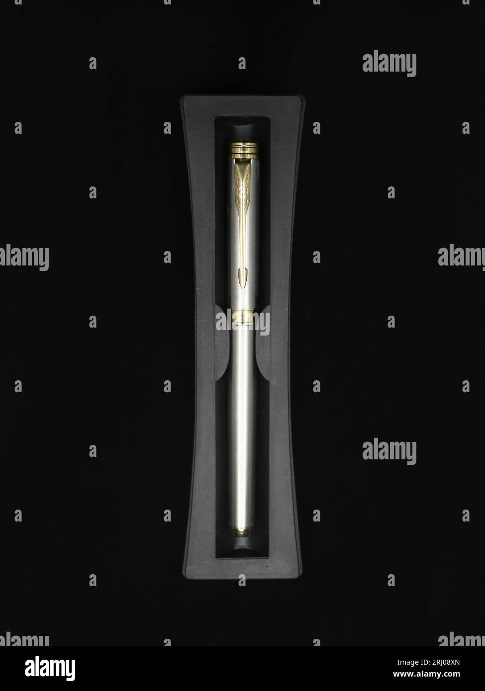 top view of a limited edition silver color business pen made of stainless steel isolated in a black background Stock Photo